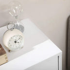 White cabinet top with alarm clock and decorative items