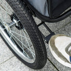 Pet stroller wheel detail with treaded tire, metal frame, and sturdy axle mount