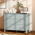 Green fluted six-drawer dresser with gold knobs and flat top for decor items