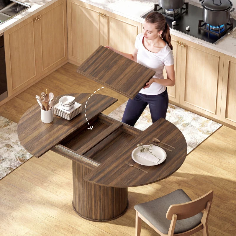 Dark walnut round dining table with extension boards pulled out from hidden leaf storage