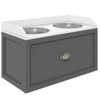 Grey raised dog feeding station with two stainless steel bowls and front storage drawer.