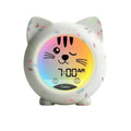 Cat-shaped sleep trainer clock with glowing face display and white speckled body