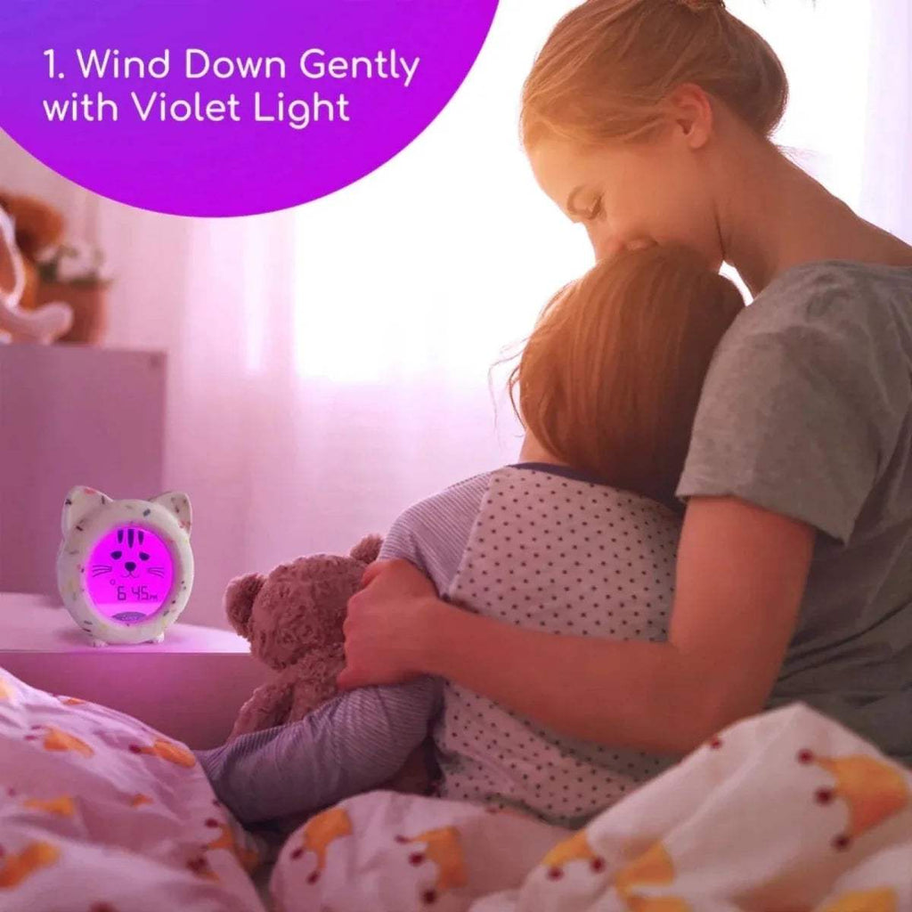 Cat sleep trainer clock showing purple glow and smiling face on circular display