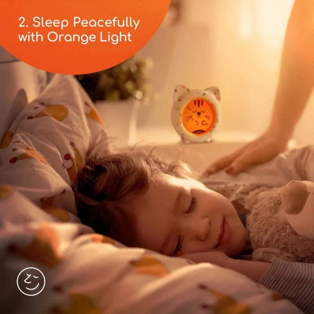 Cat sleep clock with orange-lit display and cartoon face on white confetti body
