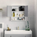 Bathroom wall storage cabinet with grey interior shelves behind mirrored door panels