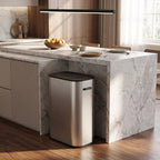 Stainless steel sensor waste bin placed under kitchen counter