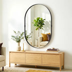 Black oval wall mirror with thin frame and clear reflective glass