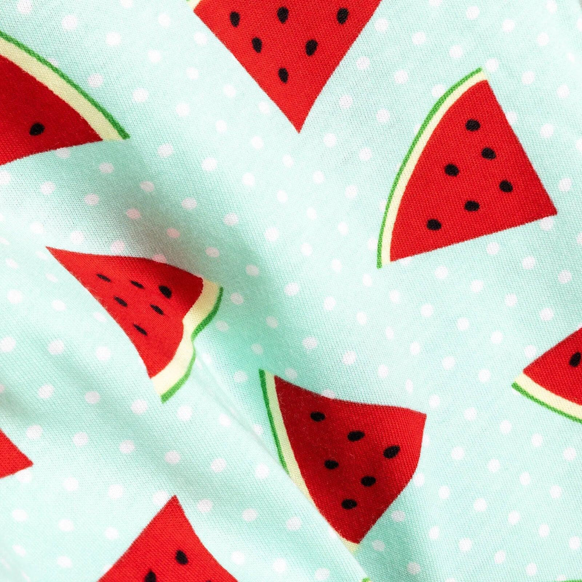 Mint pajama fabric close-up with red watermelon slices and small white dots