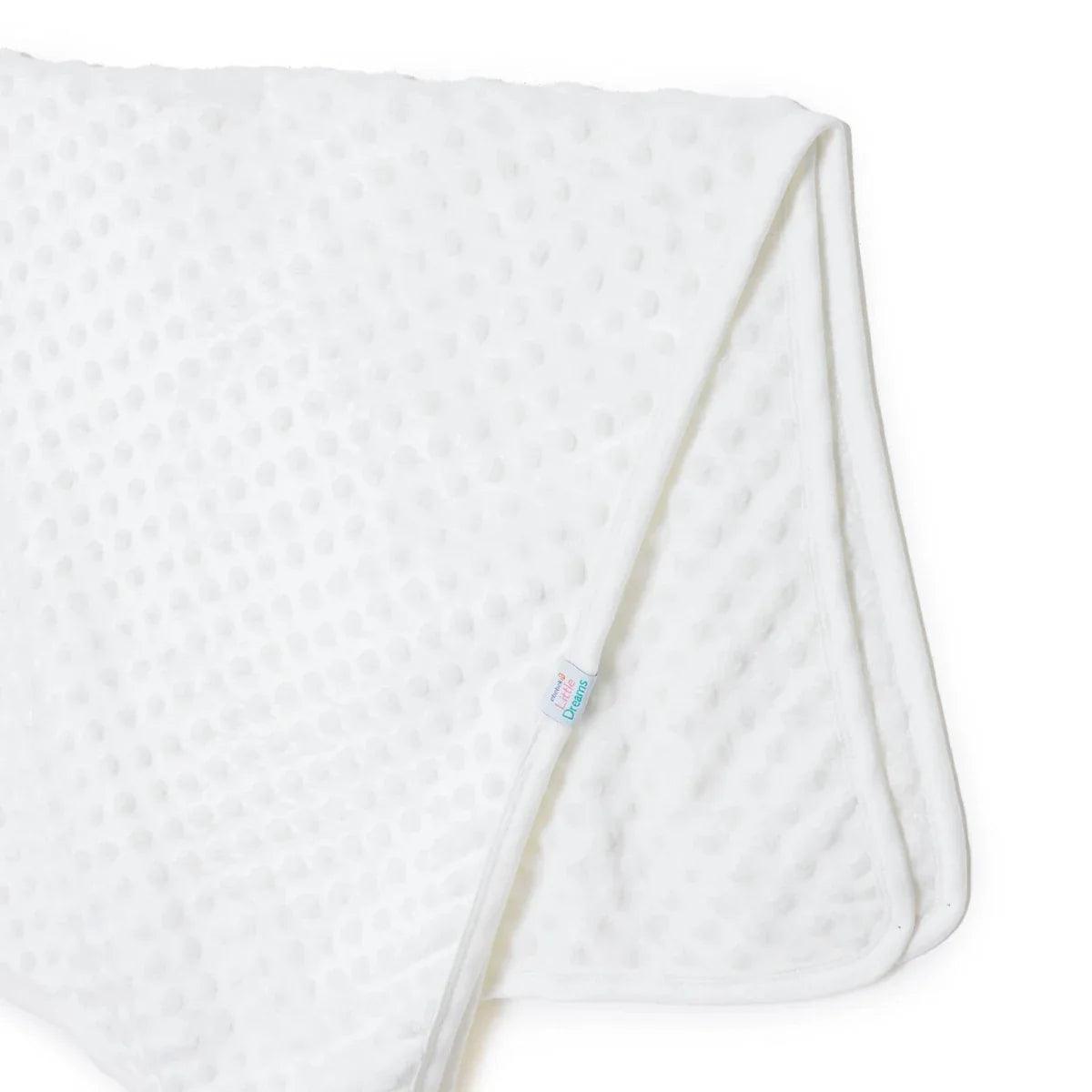 Ecru fleece baby blanket corner with “Little Dreams” label and stitched edge seam