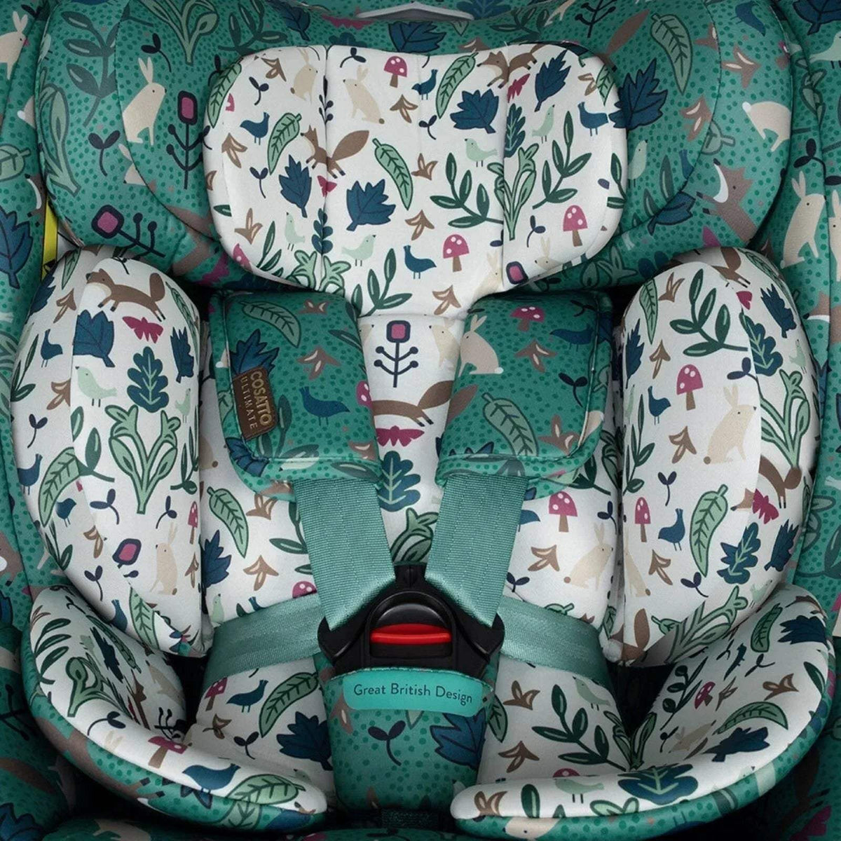 Interior view of green car seat with woodland print inserts and padded harness