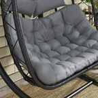 Close-up of gray tufted cushion on black woven hanging egg chair seat