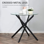 Round clear glass dining table with black X-shaped metal legs and sturdy base