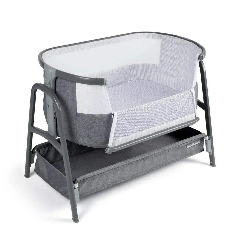 Grey bedside crib with open side panel, fitted padded mattress base, and curved canopy.