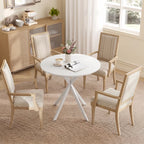 White round dining table with tripod legs paired with four woven chairs