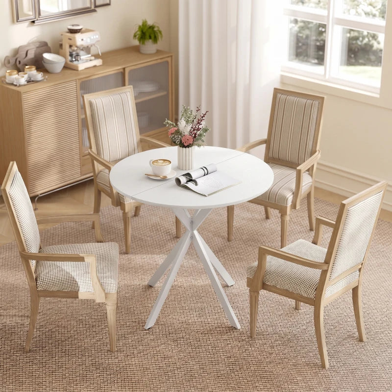 White round dining table with tripod legs paired with four woven chairs