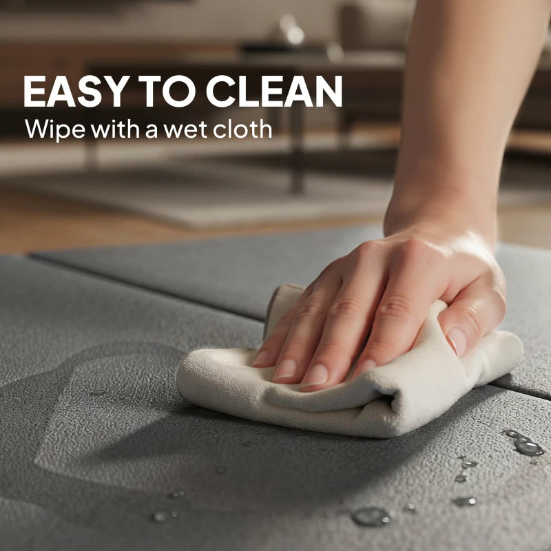 Grey exercise mat being wiped clean with a cloth, padded foldable surface