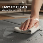 Grey exercise mat being wiped clean with a cloth, padded foldable surface