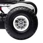 Close-up of a white kids pedal go-kart’s black tire with silver wheel rim