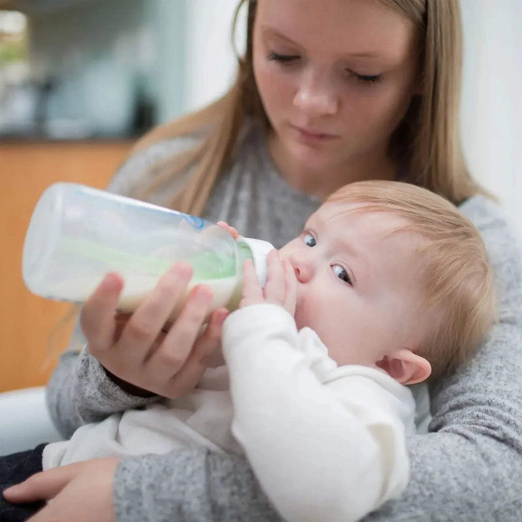 Baby drinking from wide-neck bottle with anti-colic vented nipple