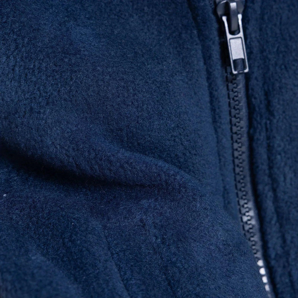 Navy blue fleece gilet close-up of seam and zipper