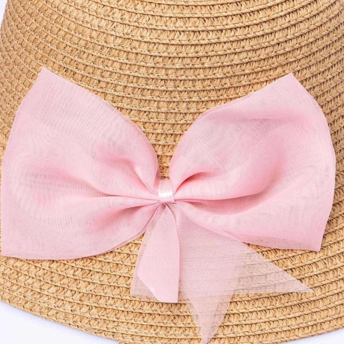 Straw bucket hat close-up: pink bow ribbon with layered tails on brim