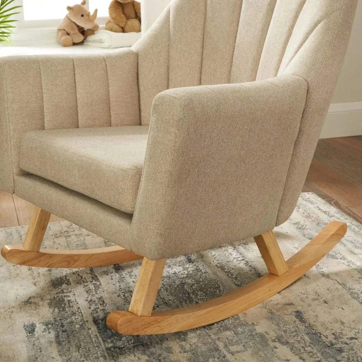 Stone fabric rocking chair with curved wooden base and matching foot stool.