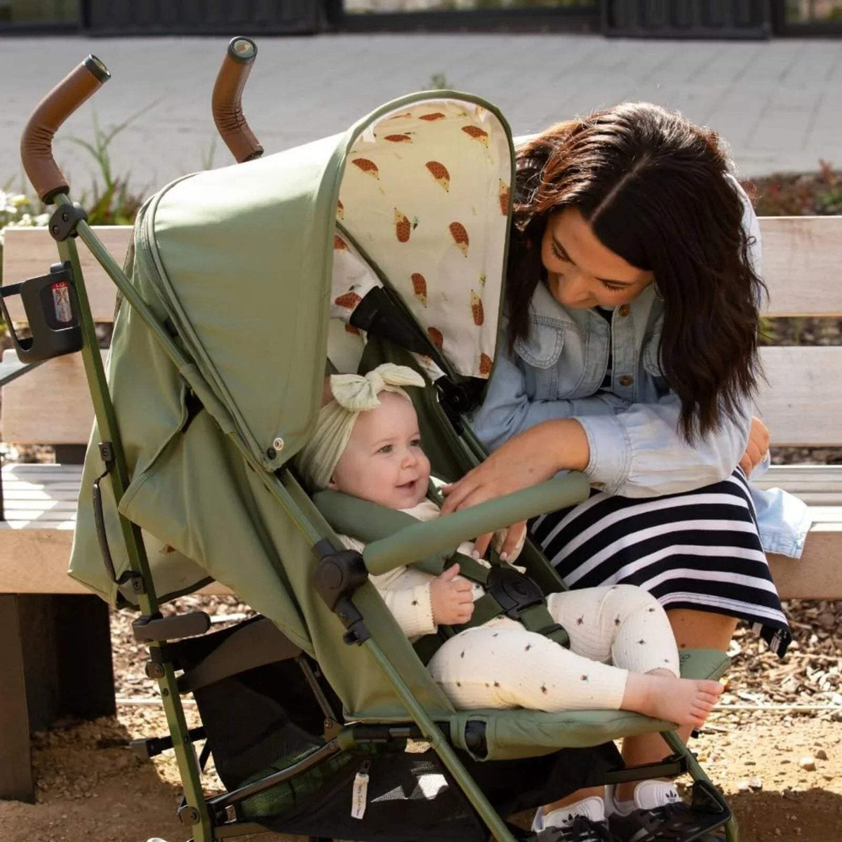 Cosatto Supa 3 stroller outdoors with hedgehog-print canopy and green seat cover