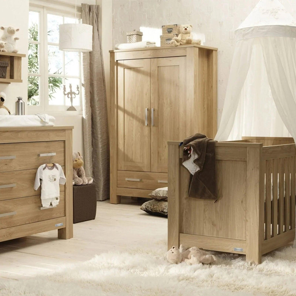 Oak wood nursery furniture set with cot bed, wardrobe, and dresser in matching finish