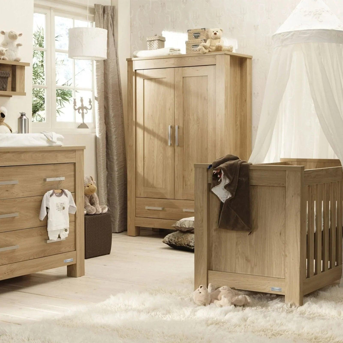 Oak wood nursery furniture set with cot bed, wardrobe, and dresser in matching finish