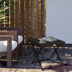 Brown folding rattan side table with woven top and folding cross-leg frame