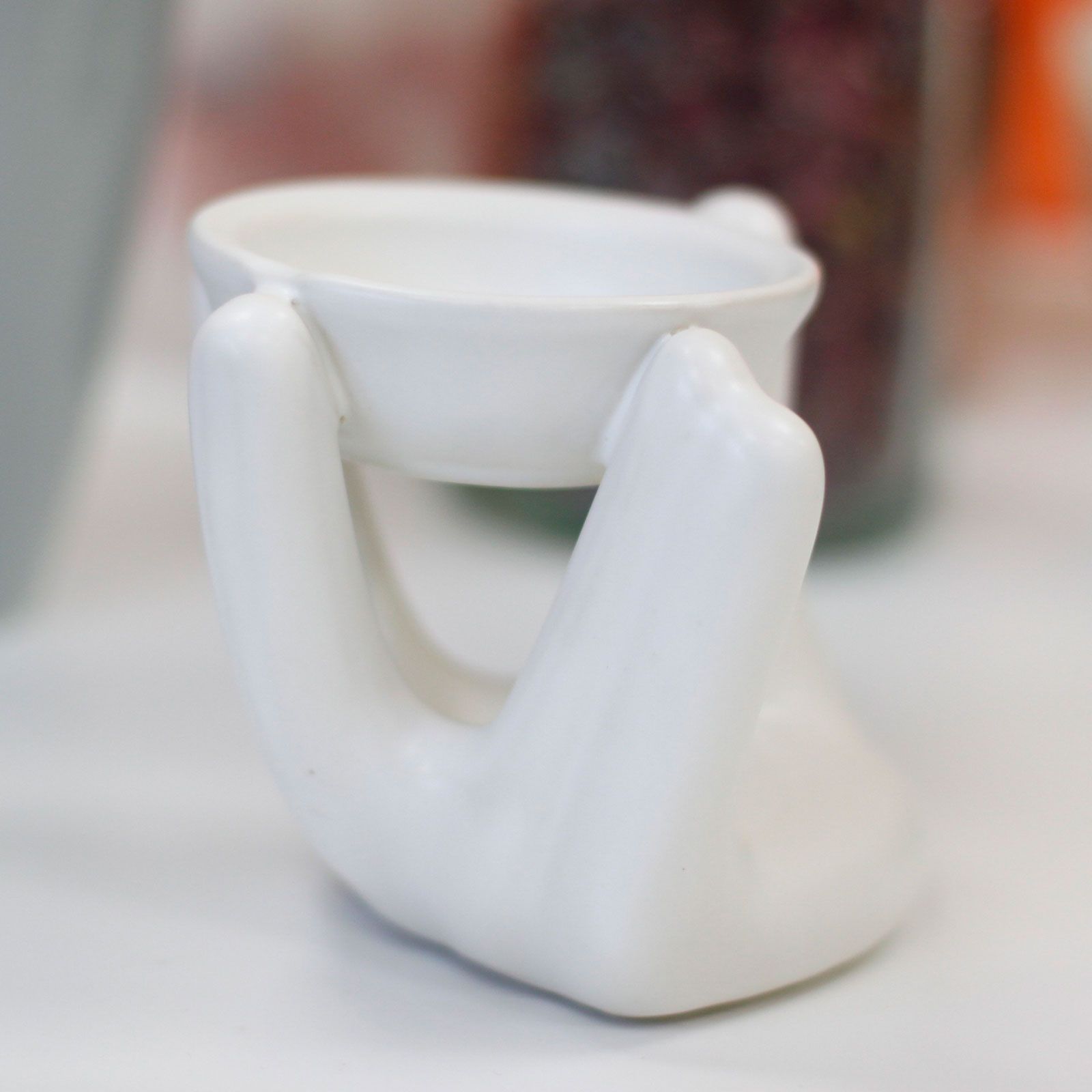White ceramic oil burner with abstract design on a white background