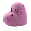 Pink heart-shaped bath bomb with dark speckle accents, rounded shape.