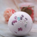 White fig bath bomb with purple and teal unicorn-shaped sprinkles