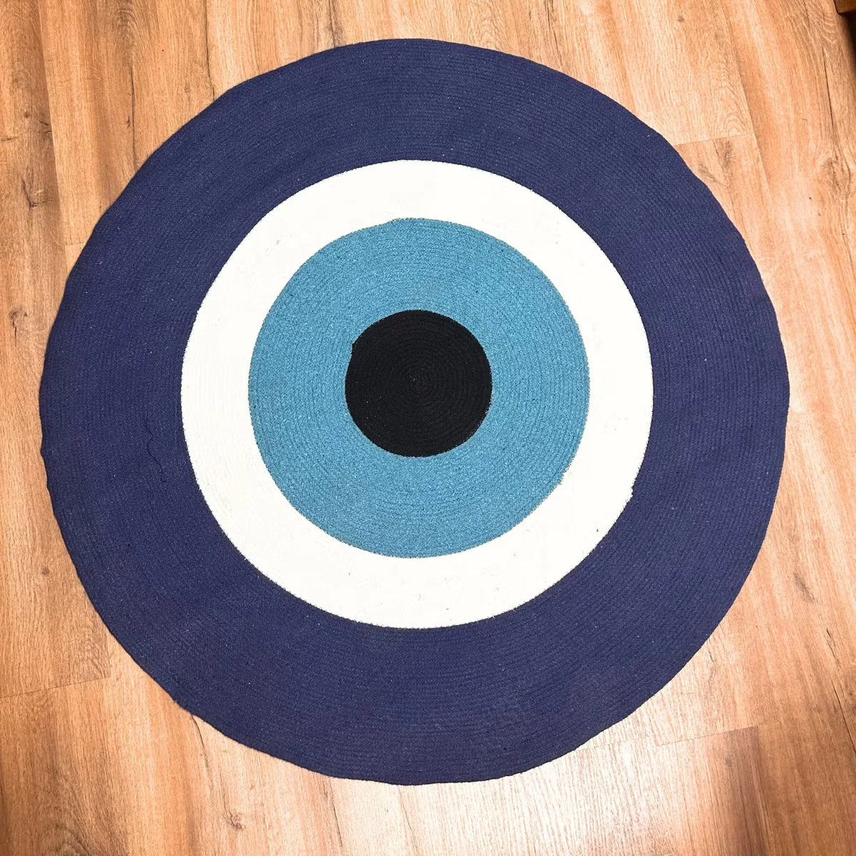 Round cotton rope eye rug with navy, teal, white rings and black center