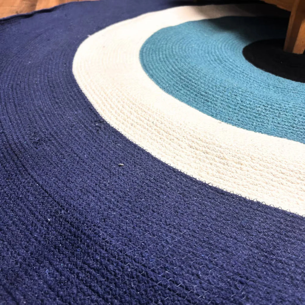 Cotton rope eye rug close-up: navy textured surface with white border and teal ring