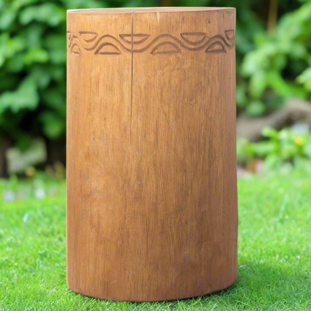 Wooden cylindrical stool with carvings on a white background