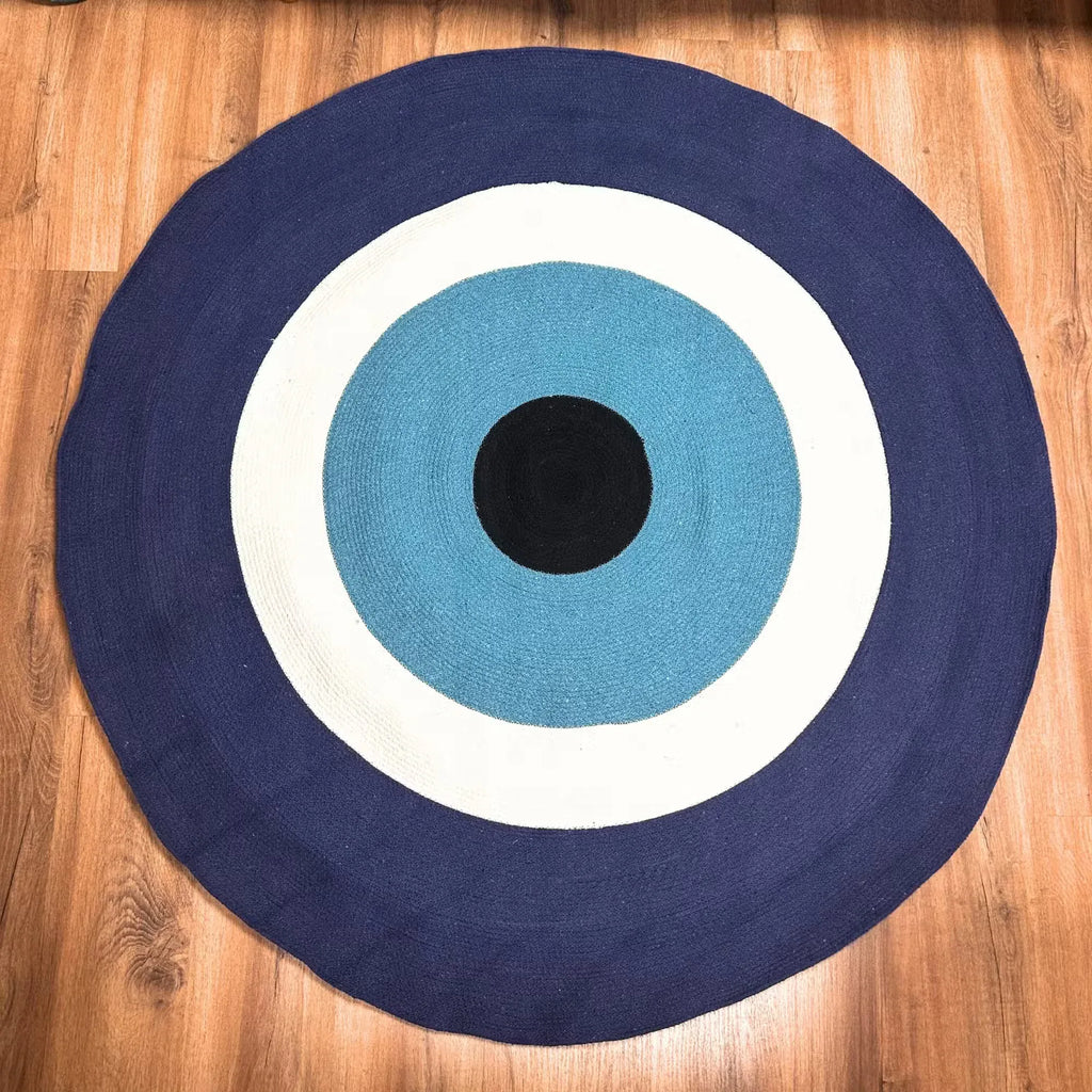 Round cotton rope eye rug with navy, sky blue, white rings and black center.