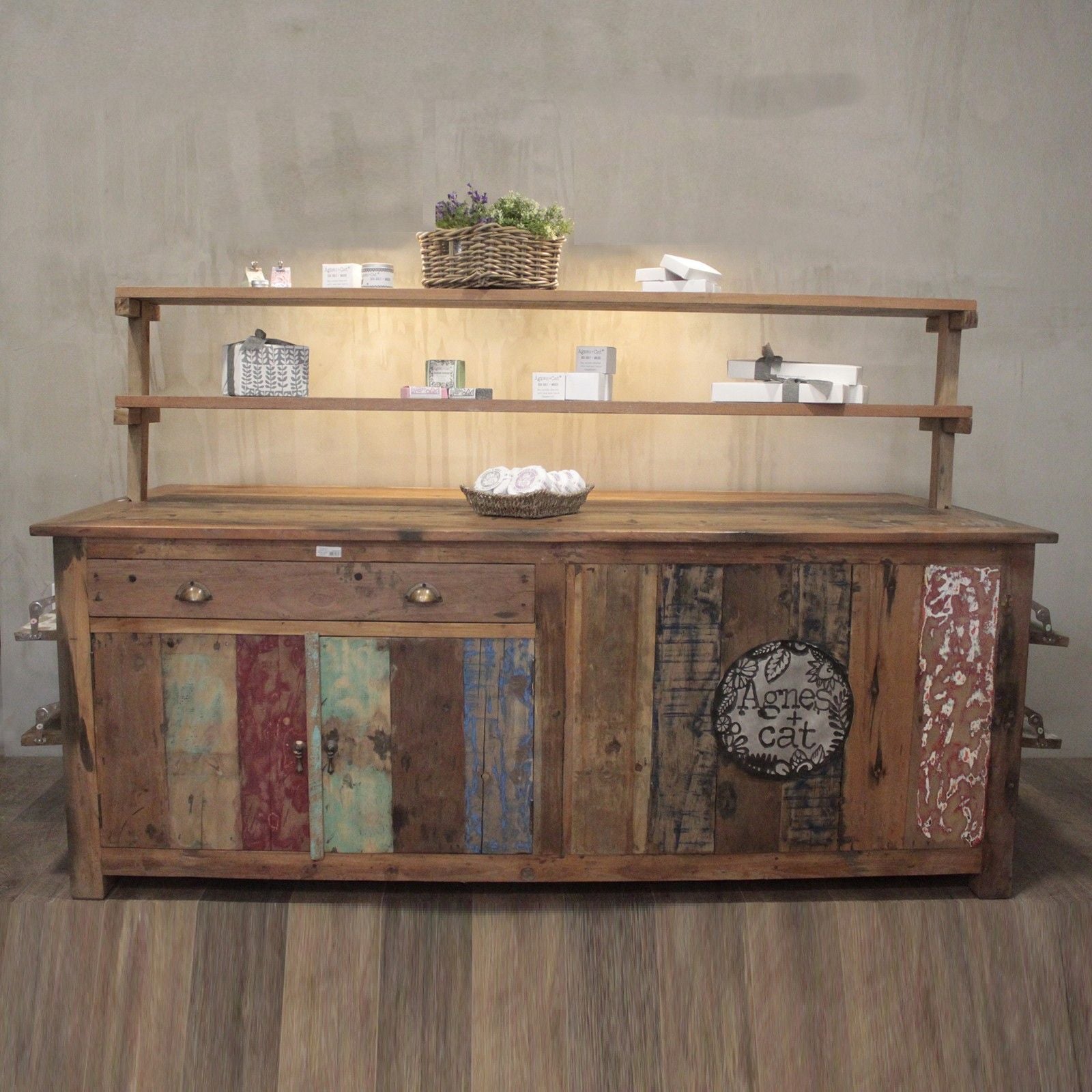 Wooden shelf with decorative items against a plain wall