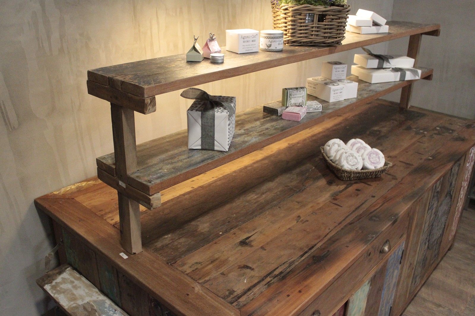Wooden shelf with various items on a neutral background