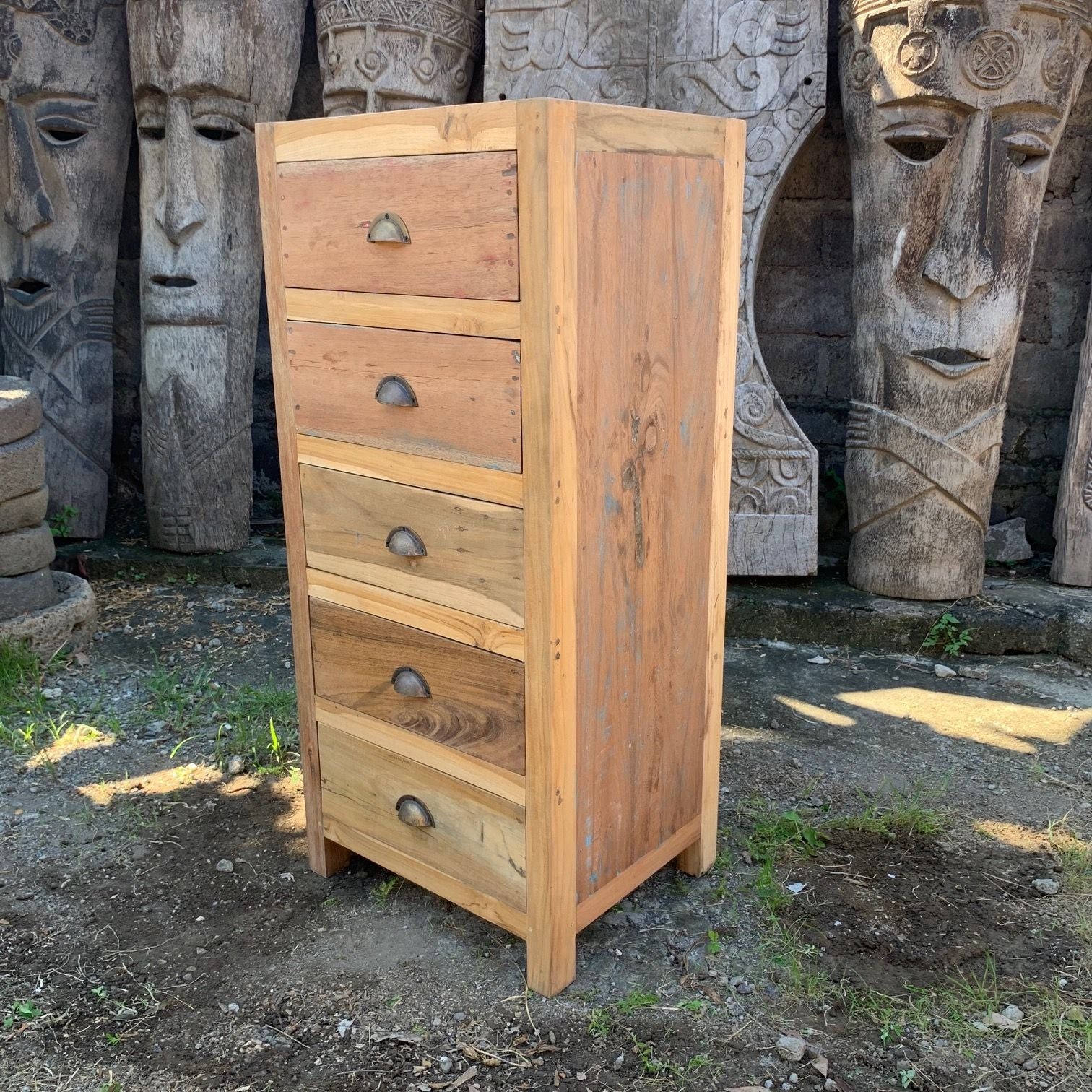 Wooden dresser with four drawers in front of stone statues