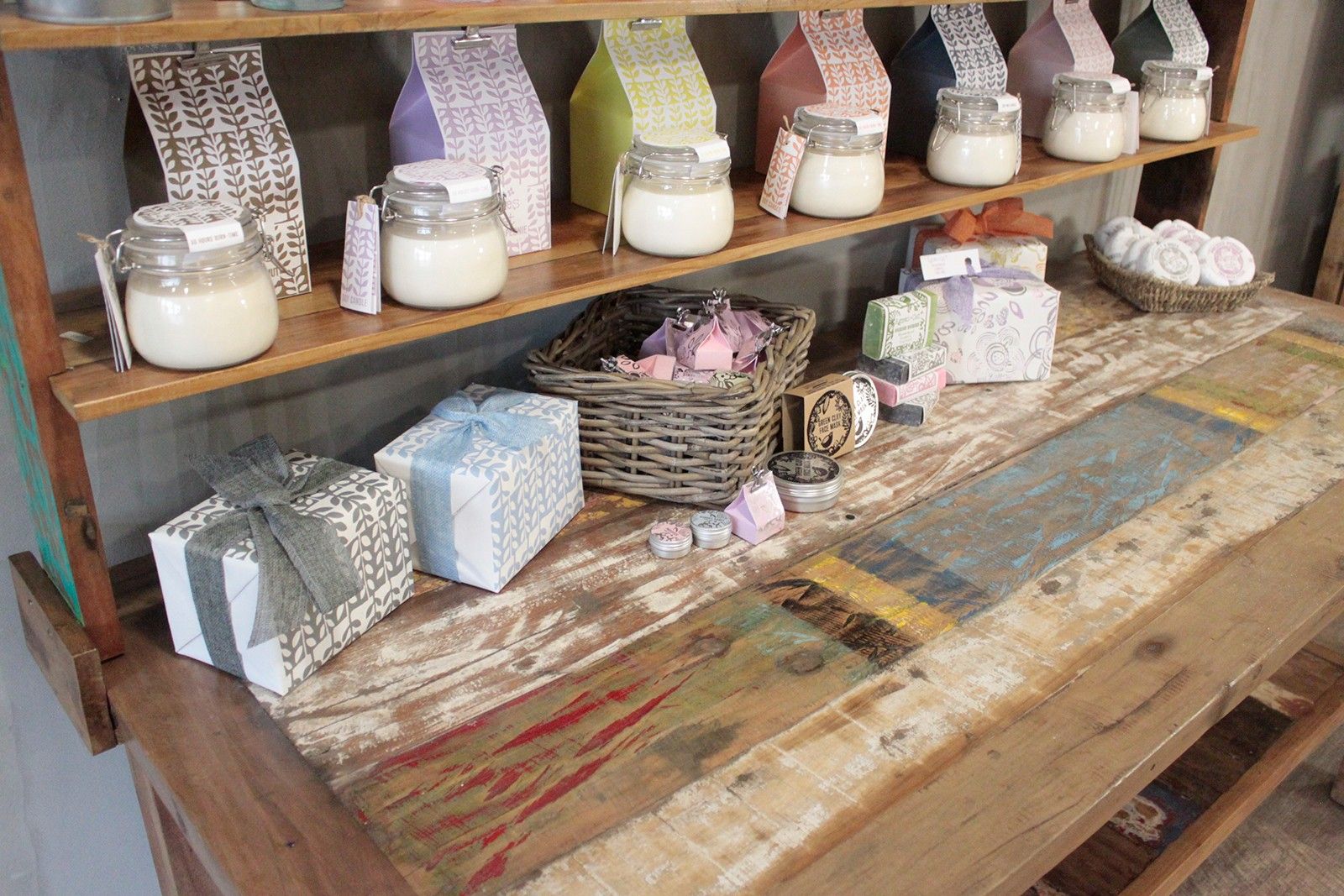 Wooden shelf with various jars, boxes, and decorative items on a textured wooden surface.