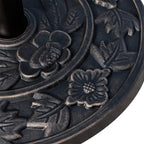 Close-up of embossed rose and leaf motifs on bronze tone half-round umbrella base