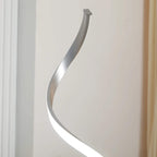 Silver spiral LED floor lamp with curved glowing tube and tall wavy stem