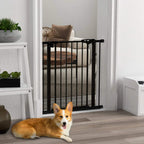 Black safety gate with vertical bars installed in a doorway, with pet nearby.