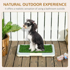 Indoor artificial grass puppy training pad with a seated dog on the green surface