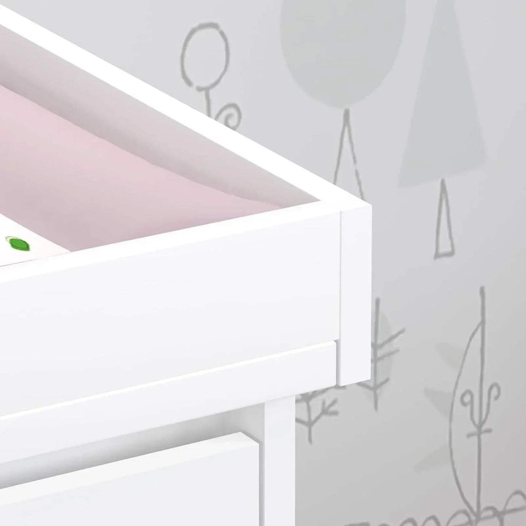 Close-up of white changing unit side rail and open storage shelf edge