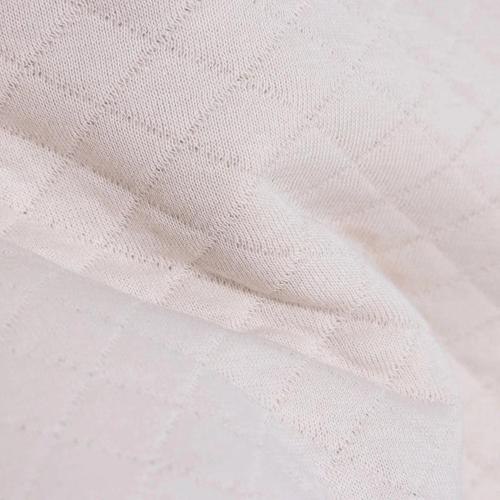 Beige quilted-texture knit fabric close-up on baby sweatshirt