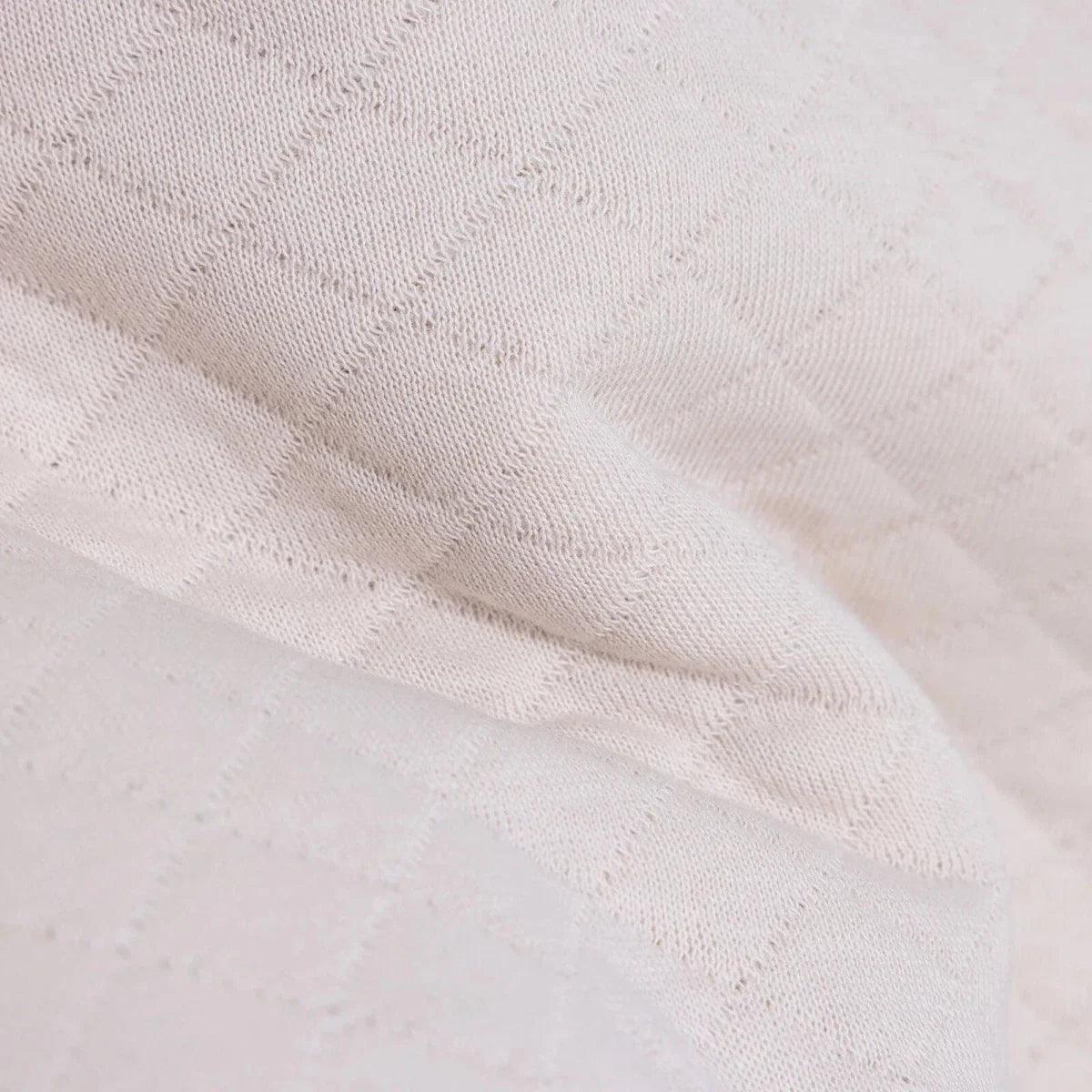 Beige quilted-texture knit fabric close-up on baby sweatshirt