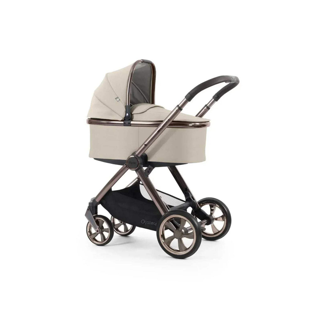 Buttermilk carrycot on stroller frame with four wheels and dark handlebar