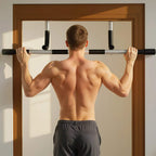 Man using a doorway pull-up bar, black foam handles on curved silver frame